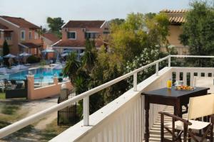 a balcony with a table and a view of a pool at Sofia Apartments in Sidari