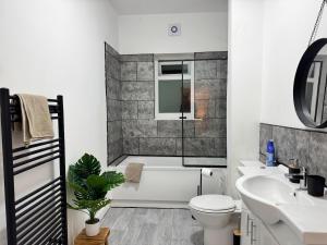 a bathroom with a tub and a toilet and a sink at 3 BD Luxury Stay For Contractors & Families in Newcastle upon Tyne