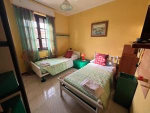 a small room with two beds and a window at Case vacanze Efisio e Vilma in Santa Giusta