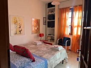 a bedroom with a bed and a chair in it at Case vacanze Efisio e Vilma in Santa Giusta