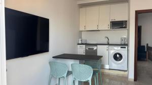 a kitchen with a table and chairs and a washing machine at CASA ENTERA PLAYA PUERTO del ROSARIO in Puerto del Rosario