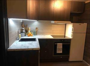 Una pequeña cocina con fregadero y refrigerador. en Karnes Lodge, en Oksevik
