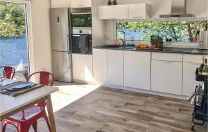 a kitchen with white cabinets and a table with chairs at Amazing Home In Borås With Wifi in Borås