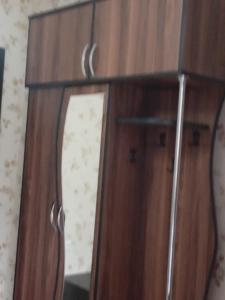 une armoire en bois avec un miroir dans une pièce dans l'établissement A cozy corner im Saburtalo 3, à Itʼkhvisi