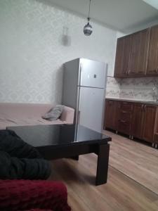 une cuisine avec un réfrigérateur et une table à l'intérieur dans l'établissement A cozy corner im Saburtalo 3, à Itʼkhvisi