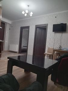 un salon avec une table au milieu dans l'établissement A cozy corner im Saburtalo 3, à Itʼkhvisi
