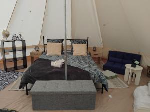 Saint-MesminLogement atypique的一间卧室，有一张床和一张蓝色沙发 更多4张照片