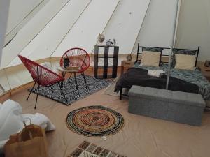 Saint-MesminLogement atypique的一间卧室，配有一张床、一张桌子和几把椅子