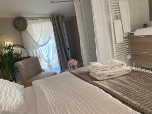 Un dormitorio con dos camas y una silla y una ventana. en L'Inattendue - Chambre Cosy à 150m de la plage, en La Bernerie-en-Retz