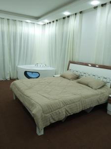 a bedroom with a bed and a bath tub at Al Eman Oasis Farm in Jal‘ad