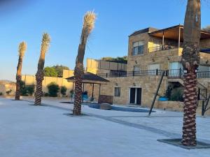 a group of palm trees in front of a building at Al Eman Oasis Farm in Jal‘ad