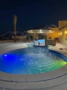 a pool with a fountain in a yard at night at Al Eman Oasis Farm in Jal‘ad +16 photos
