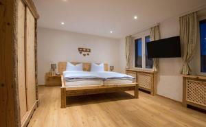 a bedroom with a bed and a flat screen tv at Gipfelhaus Gerlitzen in Arriach +25 photos