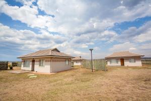 a couple of houses in a field with a sky at Ncome Lodge  +18 photos