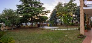 vistas a un patio con árboles y una valla en Villa MARTINA, en Ortona