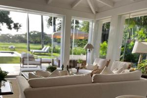Una sala de estar con muebles blancos y grandes ventanales. en Casa del Lago, en La Romana 17 fotos más