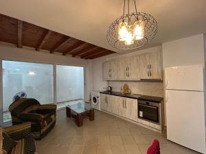 a kitchen with a white refrigerator and a living room at Duplex on Fifth in Sarandë +8 photos