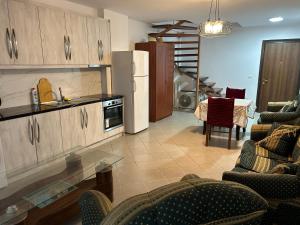 a kitchen and living room with chairs and a refrigerator at Duplex on Fifth in Sarandë