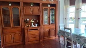 comedor con armarios de madera y mesa en Vacaciones, en Cedeira 7 fotos más