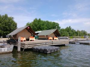 a cabin on a dock on a body of water at Safaritent 2 in Biddinghuizen
