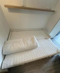 een wit bed in een kamer met een plank bij Neuf lumineux et agréable en rdc avec terrasse - 33 in Dax