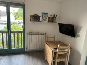een kamer met een tv en een bureau met een computer bij Neuf lumineux et agréable en rdc avec terrasse - 33 in Dax