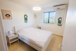 a white bedroom with a bed and a window at Luxury 2 Bedrooms Apartment in Tel Aviv- Renovated, 8Min walk to the Beach in Tel Aviv
