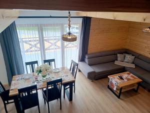 a living room with a table and a couch at Między Górami in Korbielów