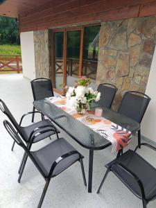 a table with four chairs and a table with flowers on it at Między Górami in Korbielów +18 photos