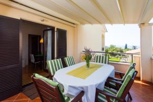 ein Esszimmer mit Tisch und Stühlen auf einem Balkon in der Unterkunft Premium Central Apartments in Vrsar