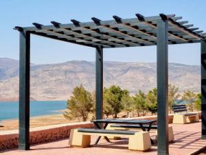 a picnic table with a view of the water at Chalet Panorama in Ouaouizarht