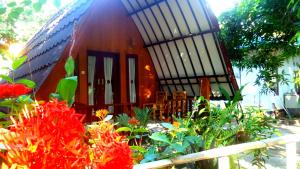 a small house with flowers in front of it at Ina Gili Guesthouse in Gili Islands