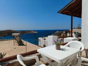 a white table and chairs on a balcony with a view of the ocean at Balcony of vari in Vári