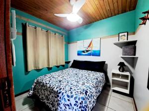 a bedroom with a bed and a blue wall at Mar&sol 80 metros da Praia Charme e Conforto in Florianópolis