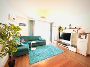 un soggiorno con un divano verde e una televisione di Bronowice Residence Blue - Homey Apartment with Garden and Parking a Cracovia
