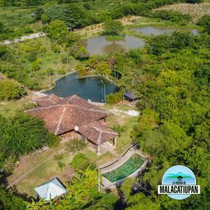 een luchtzicht op een huis met een vijver bij La Puerta de Malacatiupan in Atiquizaya