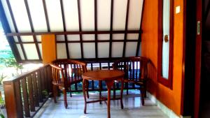 two chairs and a table on a balcony at Ina Gili Guesthouse in Gili Islands