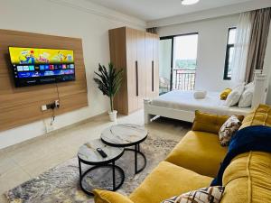 RuakaにあるModern Studio at the Loftel by Nyvin Homesのソファとテレビのあるリビングルーム