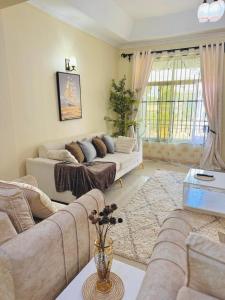 a living room with two couches and a table at In arusha nests in Arusha +3 photos