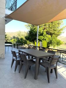 - une table et des chaises sous un parasol sur la terrasse dans l'établissement Himonas Apartments, à Pissoúri