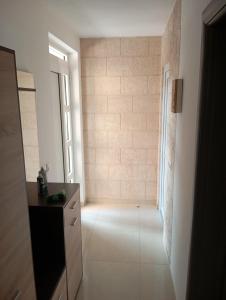 a white room with a hallway with a window at Nejla apartmani in Burtaiši +4 photos
