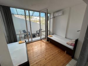 a small room with a bed and a balcony at Duplex on Fifth in Sarandë