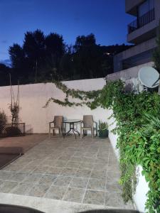 a patio with a table and chairs next to a wall at Apartment Tamara in Tivat