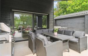 a patio with a table and chairs and a grill at 7 Bedroom Lovely Home In Ebeltoft in Ebeltoft +30 photos