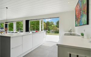 a kitchen with white cabinets and a large window at 7 Bedroom Lovely Home In Ebeltoft in Ebeltoft