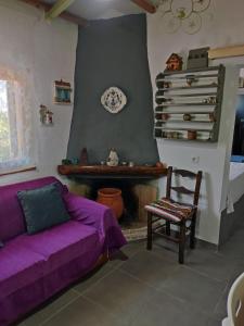 a living room with a purple couch and a fireplace at Myrovolos in Armenistis