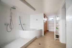 ein weißes Badezimmer mit Badewanne und Dusche in der Unterkunft Das Solaris Beach Apartment 20 mit Garten, Sauna und hundefreundlicher Ausstattung in Grömitz + 27 Fotos