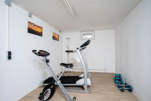 einen Fitnessraum mit einem Laufband und einem Heimtrainer in einem Raum in der Unterkunft Das Solaris Beach Apartment 20 mit Garten, Sauna und hundefreundlicher Ausstattung in Grömitz