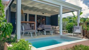 a patio with a swimming pool and a pergola at Galanterie in Grand-Bourg