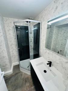 een witte badkamer met douche en wastafel bij Appartement tout neuf avec patio - 31 in Dax